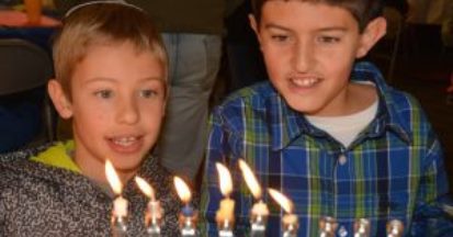 boys lighting menorah