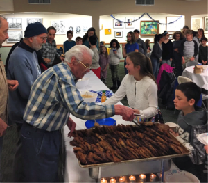 Community members enjoy latkes prepared by the Brotherhood in December, 2018.